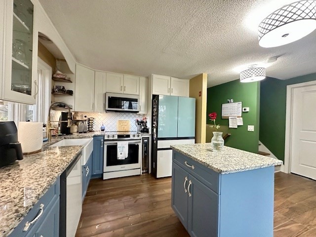 113 Harvard Street, Unit 1 Everett, MA 02149 - Photo 3 of 24 a kitchen with kitchen island granite countertop stainless steel appliances and view living room