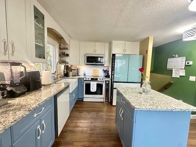 113 Harvard Street, Unit 1 Everett, MA 02149 - Photo 4 of 24 a large kitchen with a stove top oven a sink a counter space and cabinets