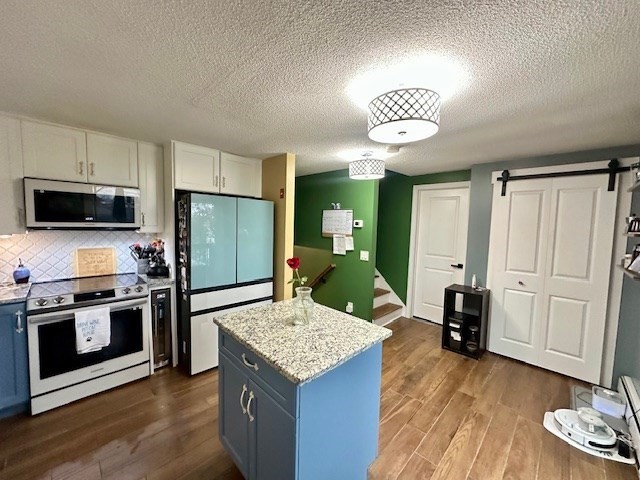 113 Harvard Street, Unit 1 Everett, MA 02149 - Photo 8 of 24 a kitchen with a stove a refrigerator and a microwave