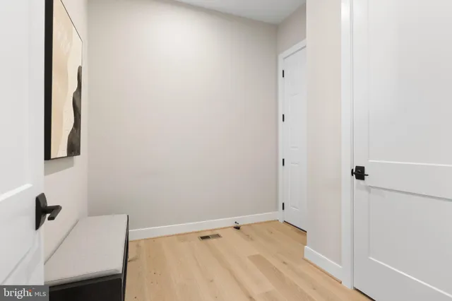 an empty room with an entryway and closet area