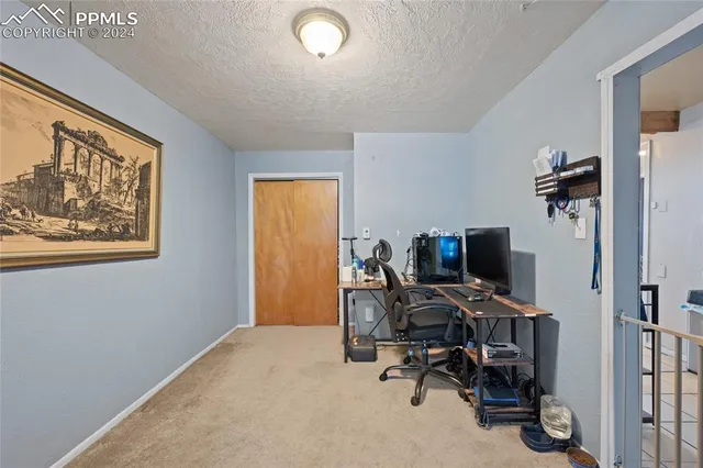 a view of a workspace with furniture and a window