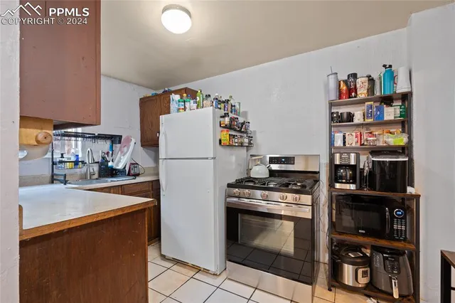 a kitchen with stainless steel appliances a stove a refrigerator a sink and a refrigerator