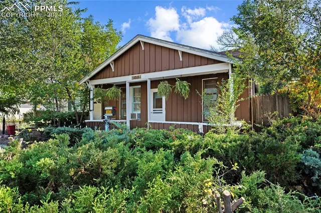 a view of a house with large windows and flower plants