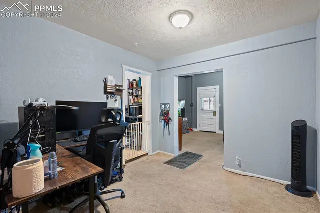 a view of a workspace with furniture and a gate