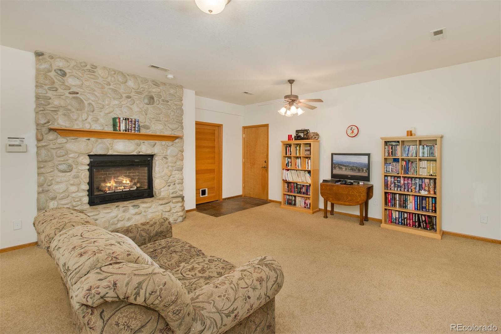 23994 Running Deer Road Conifer, CO 80433 - Photo 20 of 34 a living room with furniture and a fireplace