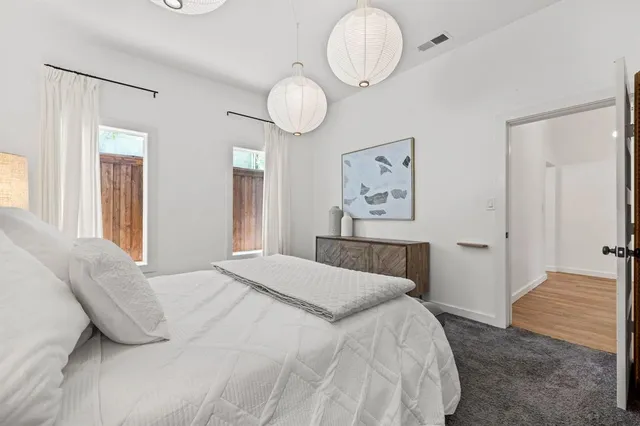 a bedroom with a bed and painting on the wall