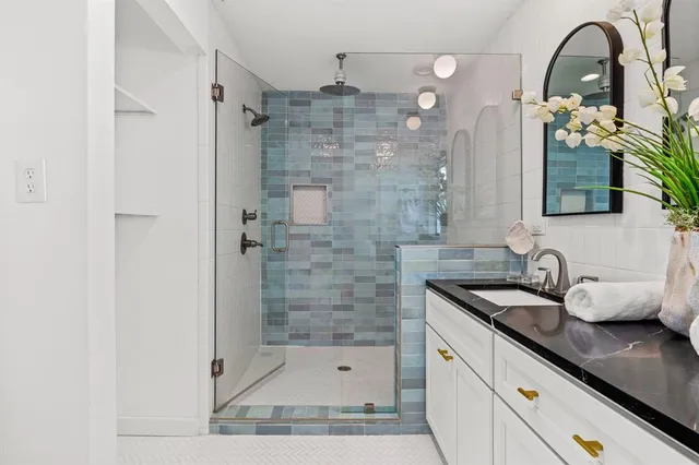 a bathroom with a shower sink and mirror
