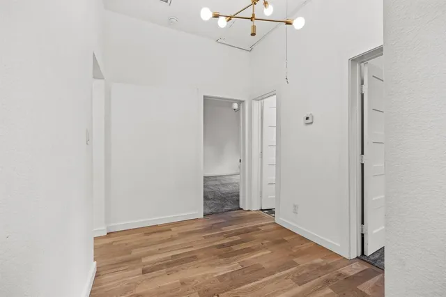 a view of empty room with wooden floor and ceiling fan