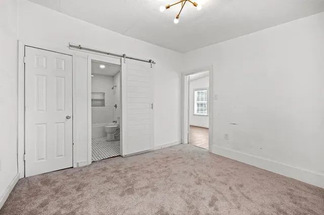 a view of an empty room and a bathroom