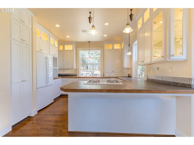 a view of kitchen with kitchen island wooden floors wooden cabinets
