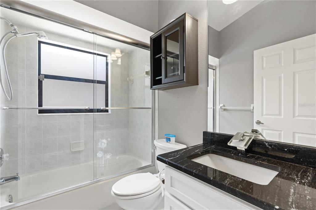 9224 Halberg Drive Hudson, FL 34669 - Photo 19 of 31 a bathroom with a granite countertop sink toilet and shower