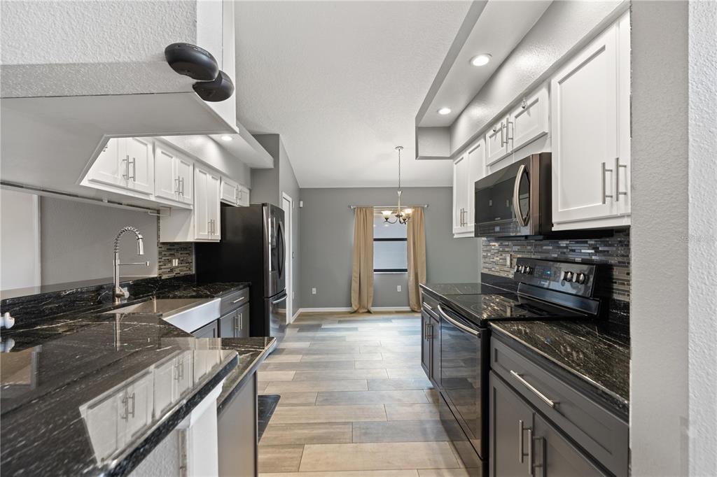 9224 Halberg Drive Hudson, FL 34669 - Photo 5 of 31 a kitchen with granite countertop a stove and a sink