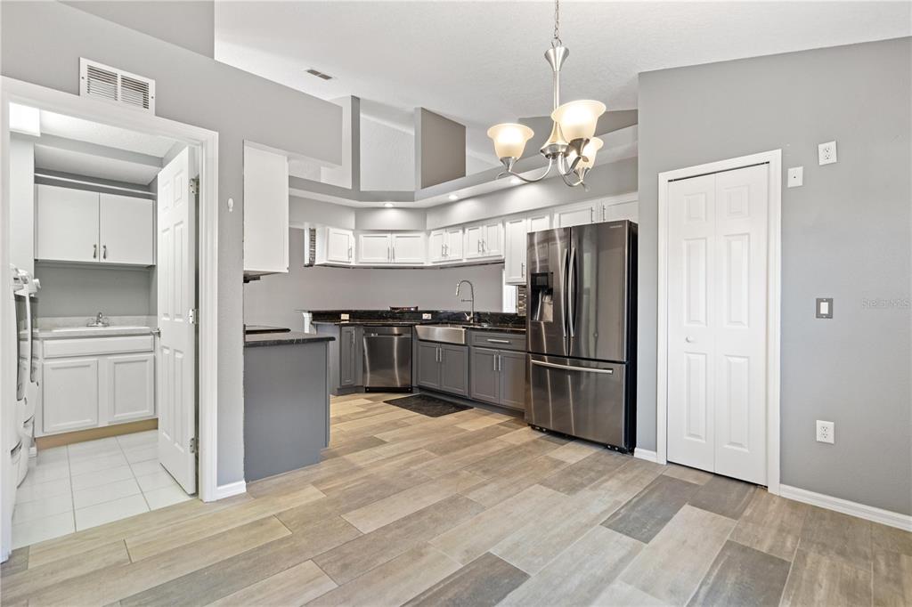 9224 Halberg Drive Hudson, FL 34669 - Photo 6 of 31 a kitchen with kitchen island granite countertop a stove a refrigerator and a sink with wooden floor