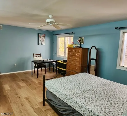 a bedroom with a bed dresser and a dining table