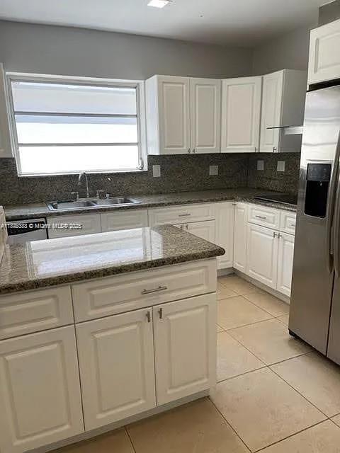 2710 Southwest 31st Avenue Miami, FL 33133 - Photo 11 of 29 a kitchen with granite countertop white cabinets and white appliances