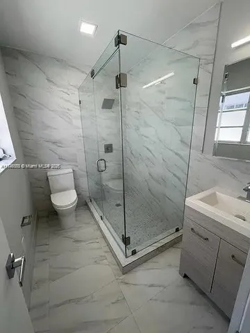 a bathroom with a shower and a toilet sink