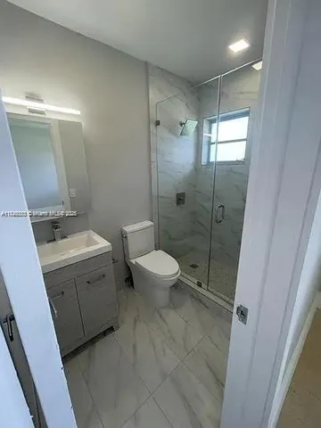 a bathroom with a double vanity sink toilet mirror and shower