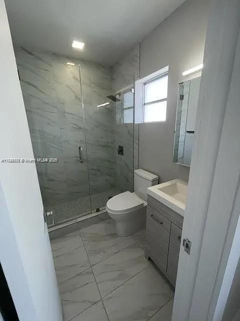 2710 Southwest 31st Avenue Miami, FL 33133 - Photo 25 of 29 a bathroom with a granite countertop shower a toilet and a sink