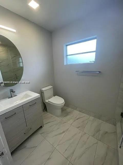 2710 Southwest 31st Avenue Miami, FL 33133 - Photo 27 of 29 a bathroom with a toilet sink and mirror