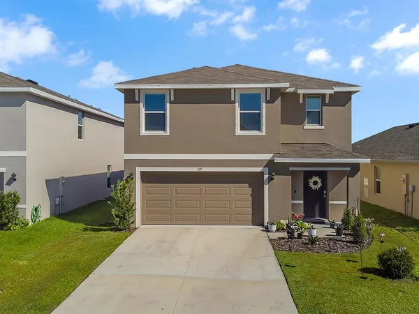 a front view of a house with a yard and garage