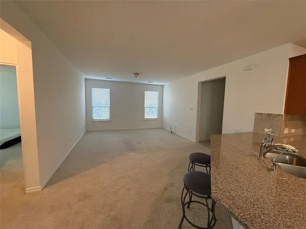 a kitchen with kitchen island granite countertop wooden cabinets a sink and a stove