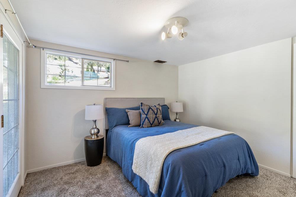 1003 Laurel Glen Road Soquel, CA 95073 - Photo 26 of 115 a bedroom with a bed and a chandelier