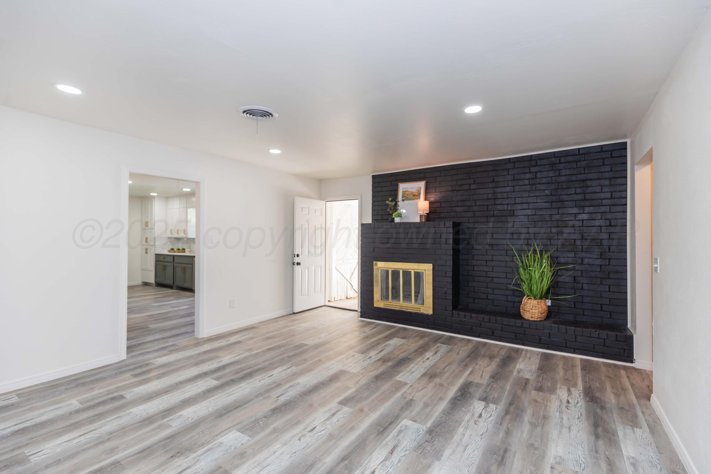 6104 Cornell Street Amarillo, TX 79109 - Photo 3 of 39 a view of an empty room with wooden floor and a window