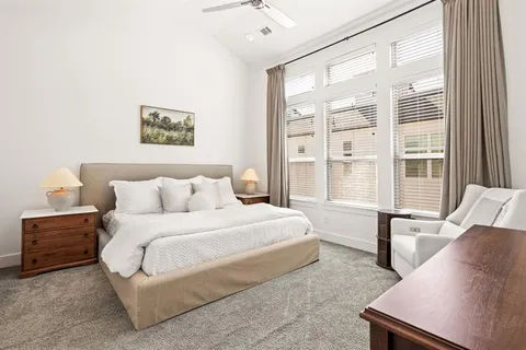 a spacious bedroom with a bed a couch and a large window