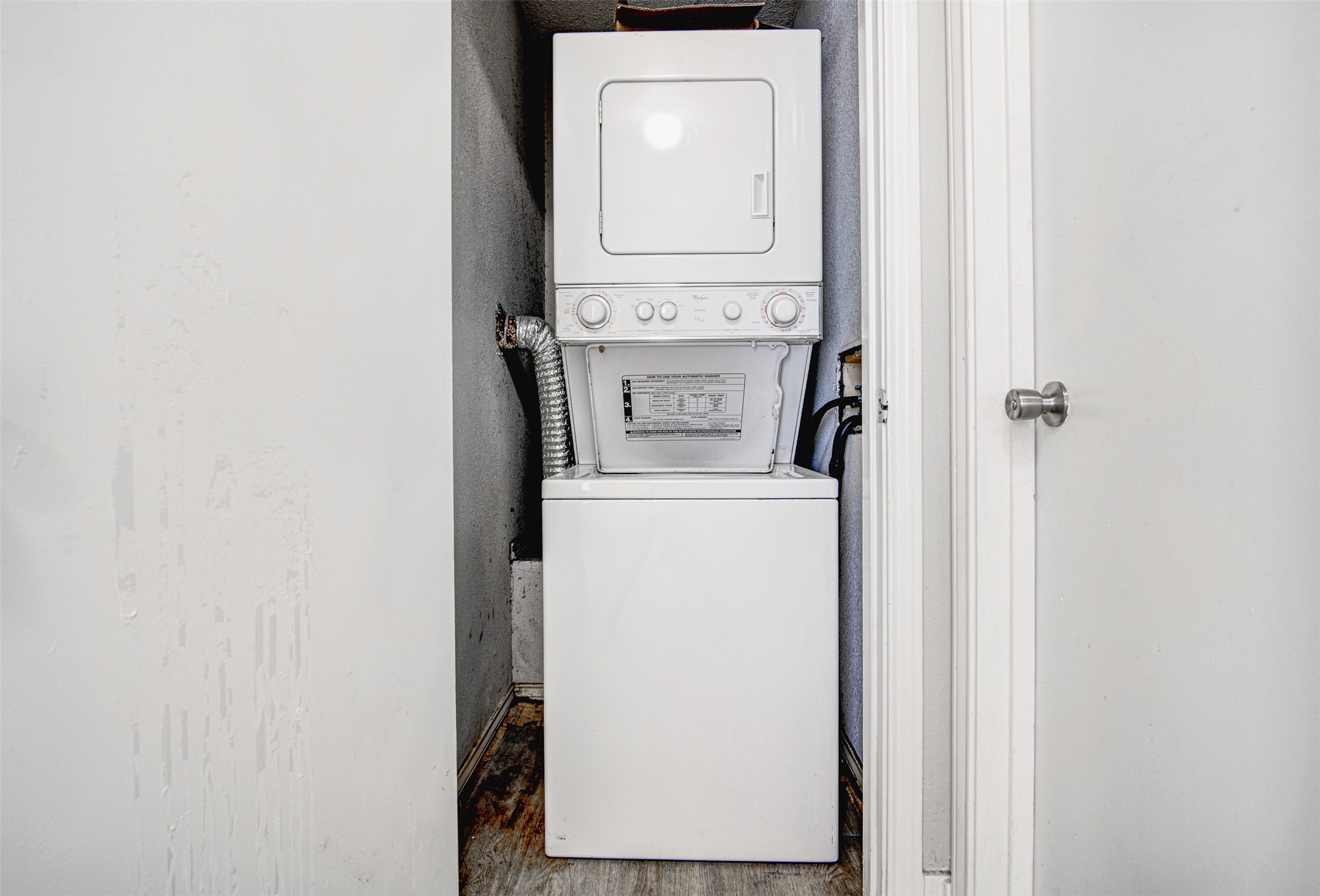 2804 Rio Grande Street, Unit 208 Austin, TX 78705 - Photo 23 of 24 A compact laundry space with a stacked washer and dryer, optimizing utility.