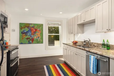 a kitchen with stainless steel appliances granite countertop a stove a sink and a microwave