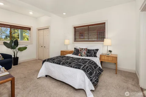 a bed sitting in a spacious bedroom next to a window