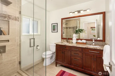a bathroom with a granite countertop sink toilet and shower