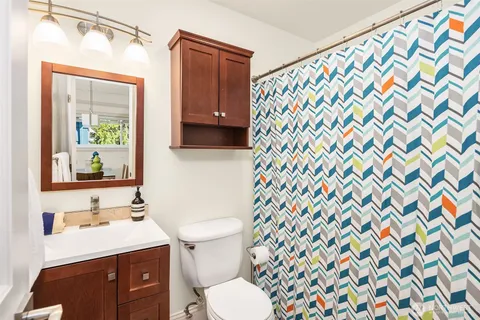 a bathroom with a sink mirror vanity and toilet