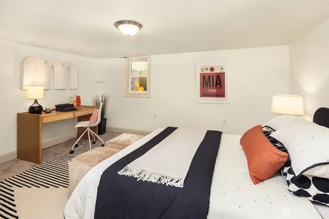 a bedroom with a bed and a lamp on dresser