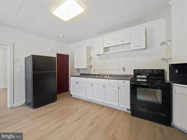 a kitchen with a refrigerator stove and white cabinets