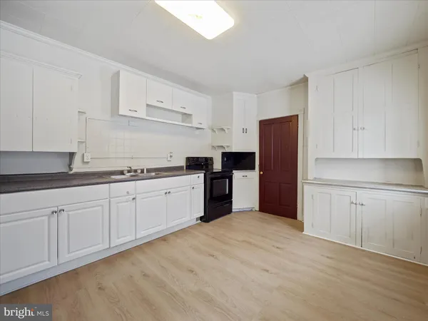 a kitchen with a refrigerator sink and cabinets