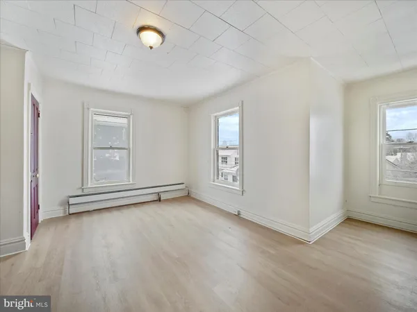 an empty room with windows and closet