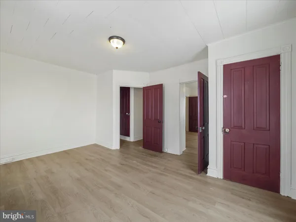 a view of an empty room with closet and entryway