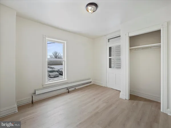 an empty room with windows and closet