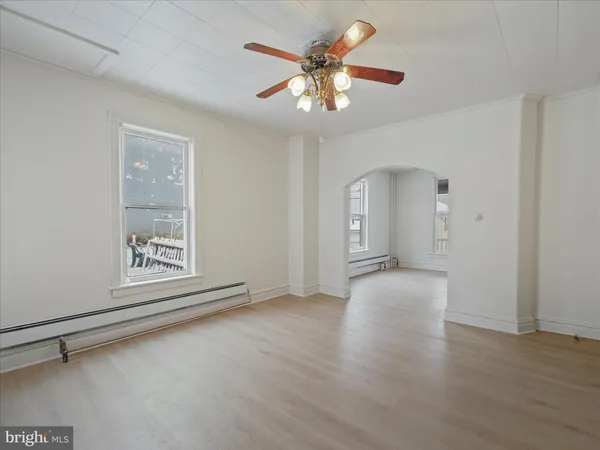 a view of an empty room with a chandelier fan