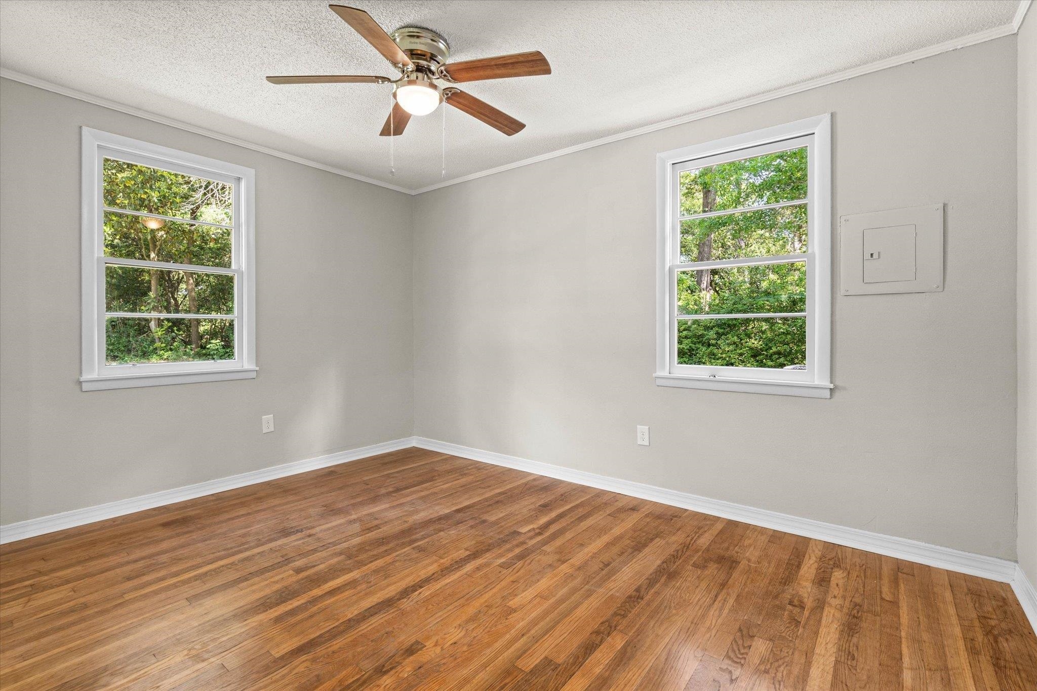 4700 Bit And Spur Road Mobile, AL 36608 - Photo 13 of 21 Unfurnished room with ceiling fan, baseboards, wood finished floors, and plenty of natural light