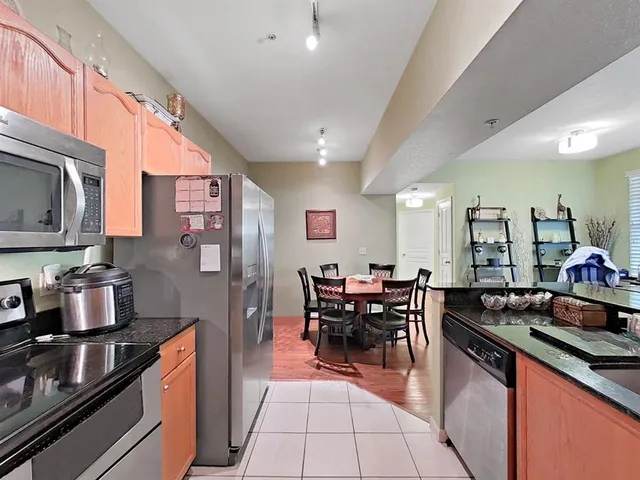 a kitchen with stainless steel appliances granite countertop a stove top oven a sink dishwasher and cabinets with wooden floor