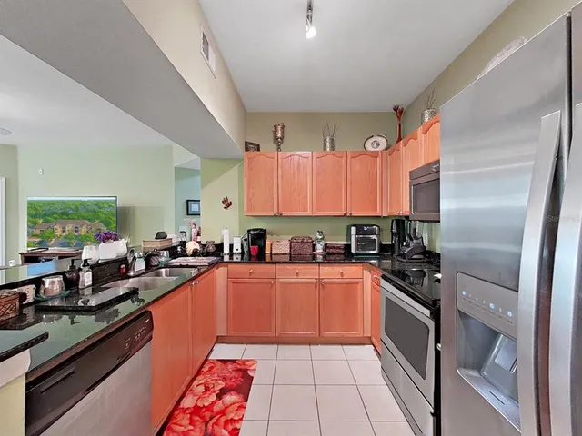 a large kitchen with stainless steel appliances granite countertop a sink stove and refrigerator