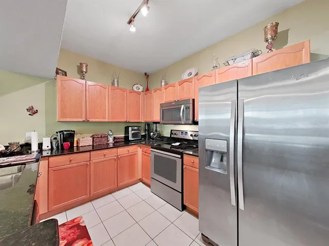 a kitchen with granite countertop a sink stainless steel appliances and cabinets