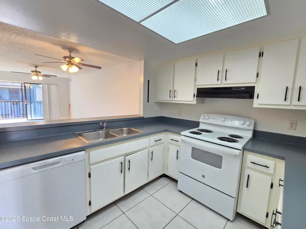 a kitchen with white cabinets and appliances