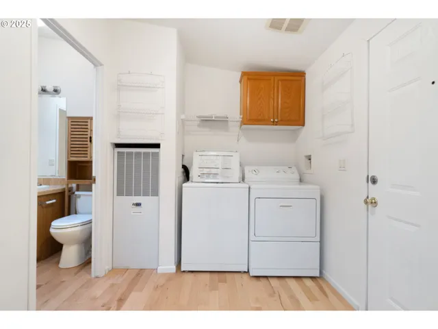 a utility room with cabinets washer and dryer