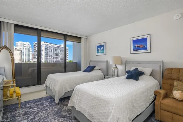 a bedroom with two beds and a large window