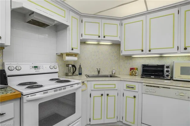a kitchen with cabinets appliances a sink and a counter top space