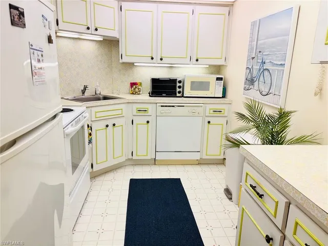 a kitchen with stainless steel appliances a white stove top oven and white cabinets