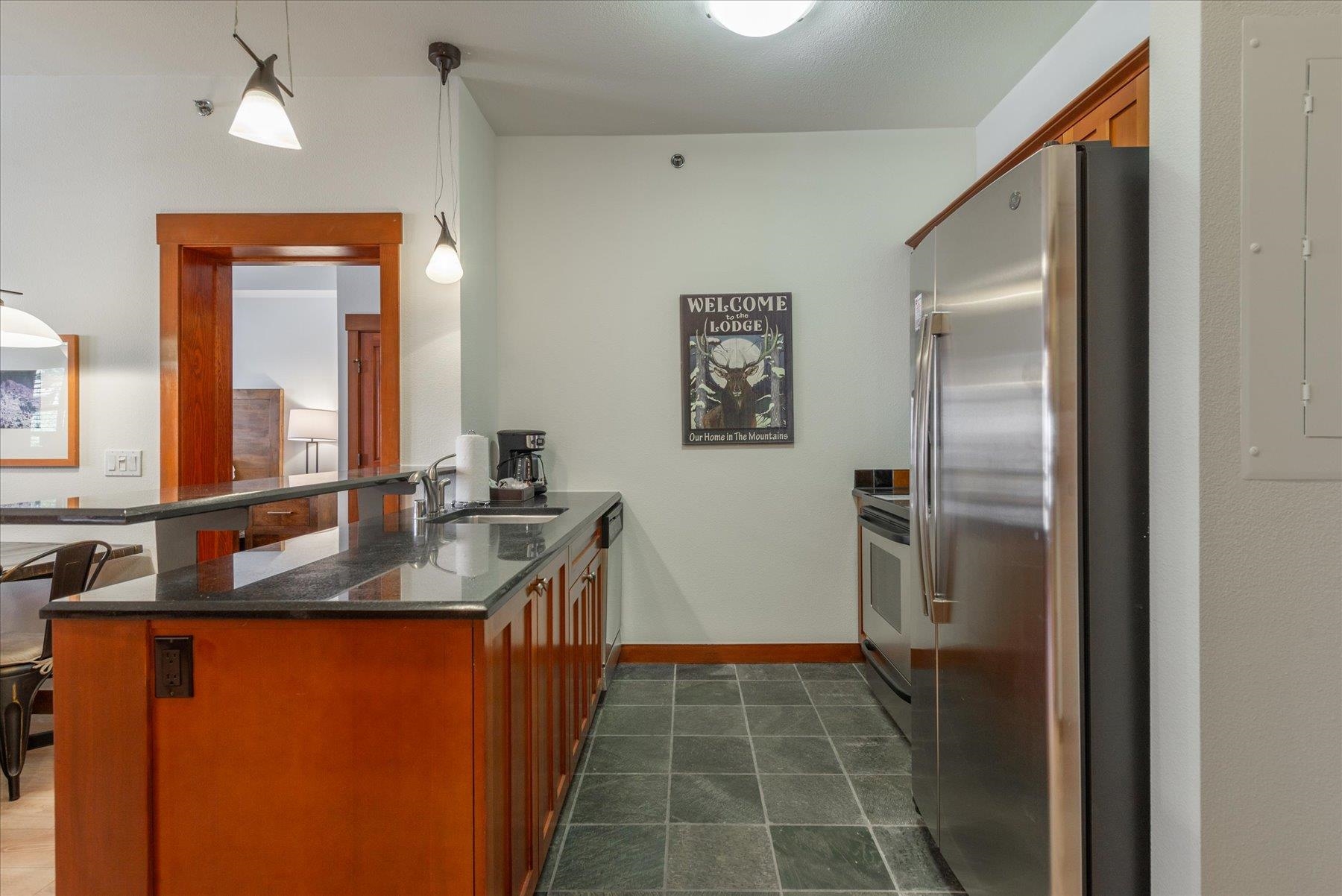 1850 Village South Road, Unit 4213 Olympic Valley, CA 96146 - Photo 4 of 17 a kitchen with stainless steel appliances granite countertop a refrigerator and a sink